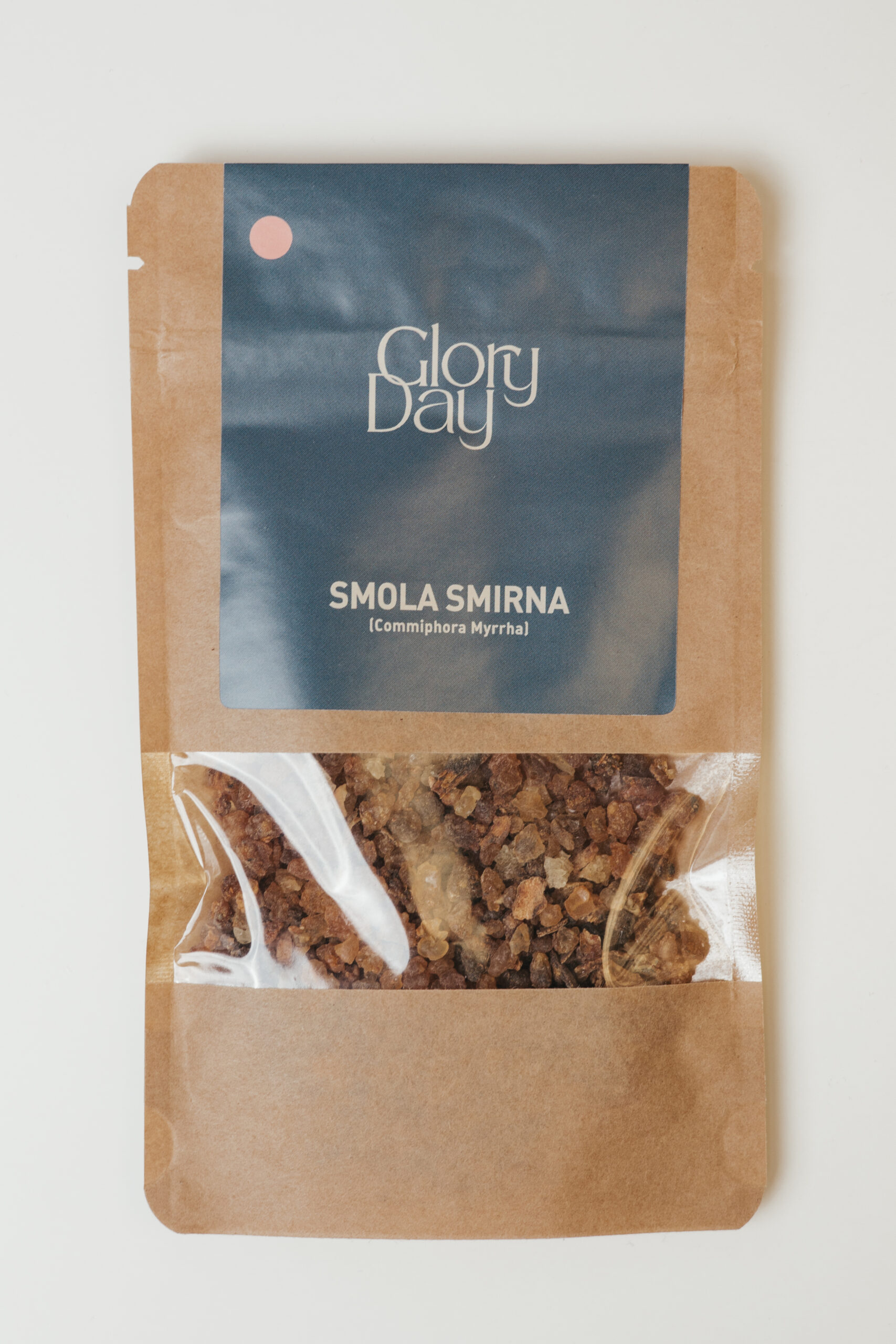Pakiranje proizvoda 'Glory Day' koje sadrži smolu mirnu (Commiphora Myrrha), prikazano u smeđoj papirnatoj vrećici brenda Glory day s prozirnim dijelom koji otkriva smeđe granule smole.