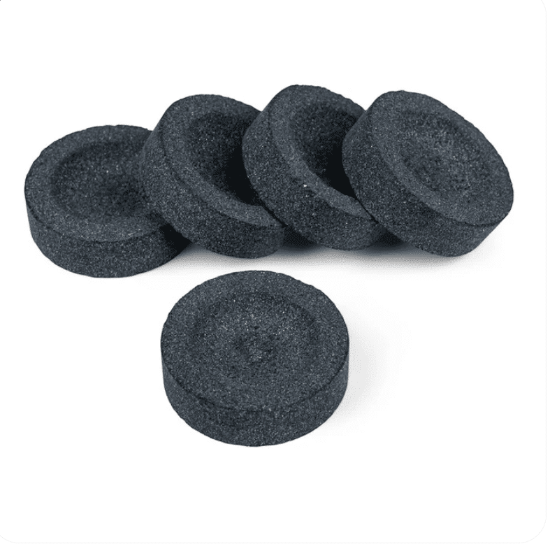 Pet crnih okruglih komada ugljena za nargilu poredanih jedan ispred drugog na bijeloj podlozi - ugljen za kađenje (briketi za smole)