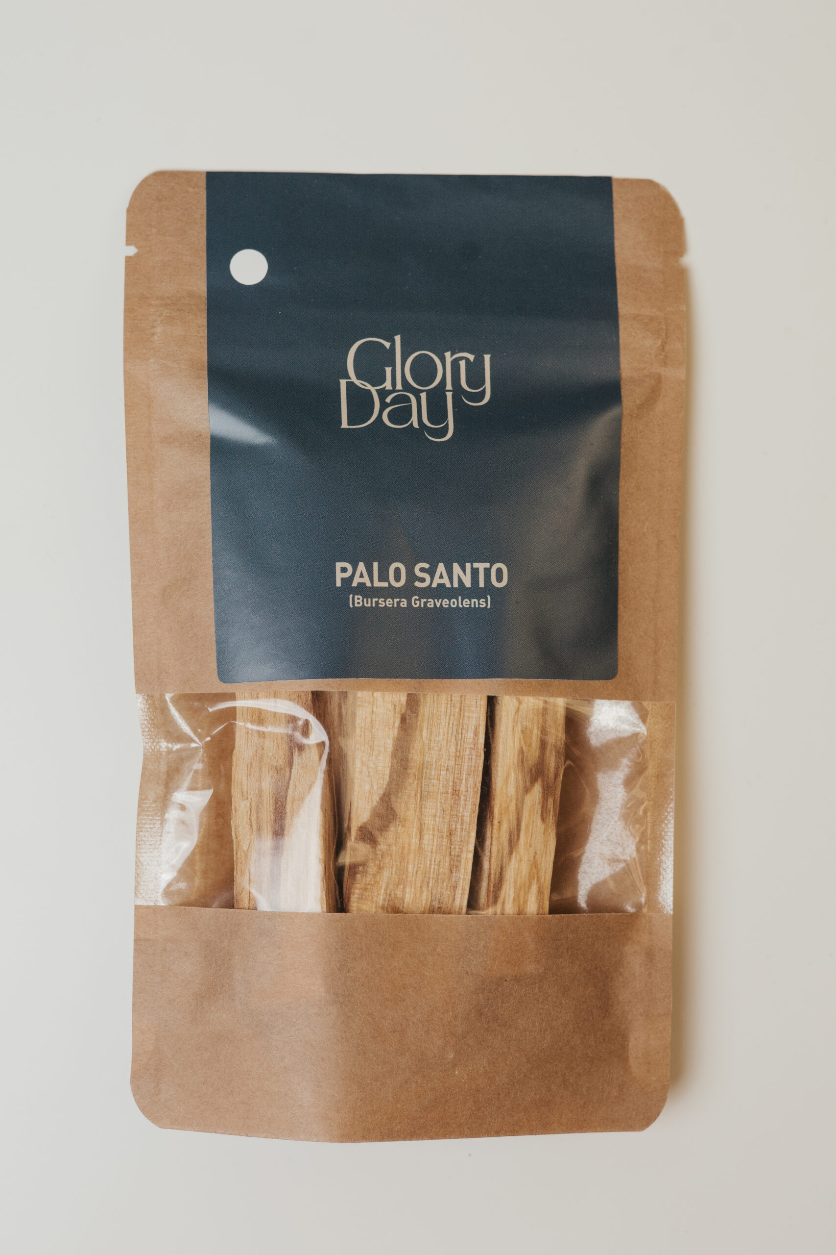 Pakiranje Palo Santo drva marke Glory Day, s natpisom "Bursera Graveolens" na papirnatoj pozadini s prozirnim dijelom koji otkriva drvene komadiće unutra.