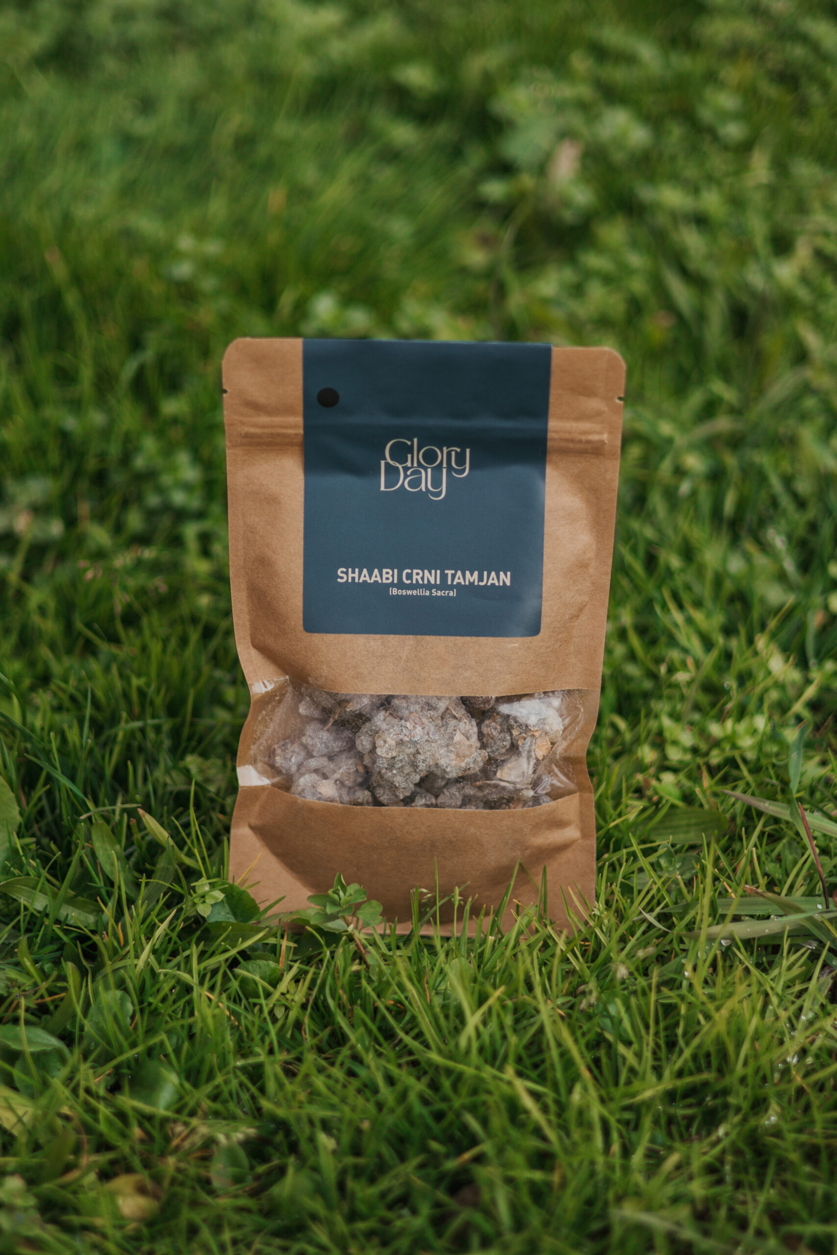 Pakiranje sa oznakom "Glory Day" i "Shaabi Crni Tamjan (Boswellia Sacra)" na travnatoj podlozi.